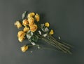 Dry bouquet of yellow roses on a black background, frustration at the end of the holidays, a sad day, toned faded faded image