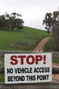 Large stop sign on a farm gate fence.