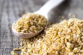 Dry bulgur grain in a wooden spoon. Healthy, dietary, vegan, gluten free product Royalty Free Stock Photo
