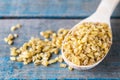 Dry bulgur grain in a wooden spoon. Healthy, dietary, vegan, gluten free product Royalty Free Stock Photo