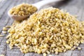 Dry bulgur grain in a wooden spoon. A pile of raw grain Bulgur porridge. Healthy, dietary, vegan, gluten free product. Healthy Royalty Free Stock Photo