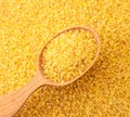 Dry bulgur in a wooden spoon on a background of cereals. The view from top Royalty Free Stock Photo