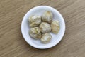 Dry candlenut in white bowl on wooden table