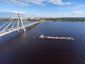 The dry cargo ship barge passes along the Sheksna River after the October cable-stayed bridge. Cherepovets, Vologda region, Russia Royalty Free Stock Photo