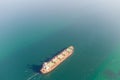 The dry cargo vessel enters the port with the help of tugs. Photo from a helicopter. Bird's-eye view.