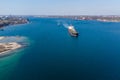 The dry cargo vessel enters the port with the help of tugs. Photo from a helicopter. Bird's-eye view.