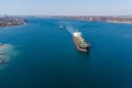 The dry cargo vessel enters the port with the help of tugs. Photo from a helicopter. Bird's-eye view