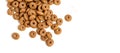 Dry cat food ringlets scattered on a white background.
