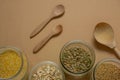 cereals in glass jars and wooden spoons top view on a beige background , zero waste kitchen concept Royalty Free Stock Photo