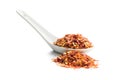 Dry chili pepper flakes in ceramic spoon. Crushed red peppers isolated on white background Royalty Free Stock Photo