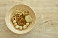 Dry Chinese yellow egg noodles dressing black sweet soy sauce with pork meatball and bean sprout in soup on bowl Royalty Free Stock Photo