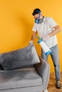 Dry cleaner& x27;s employee removing dirt from furniture in flat, closeup. Cleaning company using professional equipment.