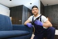 Dry cleaner's employee removing dirt from furniture in flat