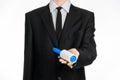 Dry cleaning and business theme: a man in a black suit holding a blue sticky brush for cleaning clothes and furniture from dust is Royalty Free Stock Photo