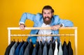 Dry cleaning service. style and people concept. Handsome man in smart casual wear looking at suits and choosing. stylish Royalty Free Stock Photo