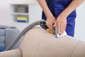 Dry cleaning worker removing dirt from sofa