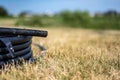 Coil of 1 inch irrigation tubing ready for new installation on top of brown and damaged dry grass. Royalty Free Stock Photo