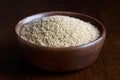 Dry couscous in brown wooden bowl. Royalty Free Stock Photo