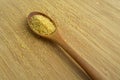 Cracked wheat daliya grains in wooden spoon, on bamboo cutting board Royalty Free Stock Photo