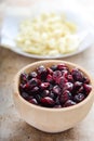Dry cranberries in wood bowl with white chocolate in wrapping paper Royalty Free Stock Photo