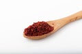 Dry and crushed chili pepper flakes in wooden spoon on white background Royalty Free Stock Photo