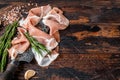 Dry cured Prosciutto crudo parma ham on a butcher knife. Dark wooden background. Top View. Copy space