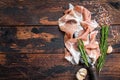 Dry cured Prosciutto crudo parma ham on a butcher knife. Dark wooden background. Top View. Copy space