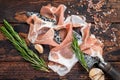 Dry cured Prosciutto crudo parma ham on a butcher knife. Dark wooden background. Top View