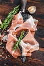 Dry cured Prosciutto crudo parma ham on a butcher knife. Dark wooden background. Top View