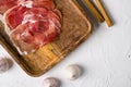 Dry cured Prosciutto crudo parma ham, on white stone table background, top view flat lay, with copy space for text