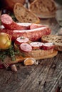 Dry-cured sausage with bread and spices on a old wooden table Royalty Free Stock Photo