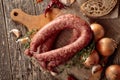 Dry-cured sausage with bread and spices on a old wooden table Royalty Free Stock Photo