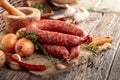 Dry-cured sausage with bread and spices on a old wooden table Royalty Free Stock Photo