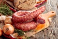 Dry-cured sausage with bread and spices on a old wooden table Royalty Free Stock Photo