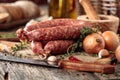 Dry-cured sausage with bread and spices on a old wooden table Royalty Free Stock Photo