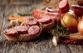 Dry-cured sausage with bread and spices on a old wooden table Royalty Free Stock Photo