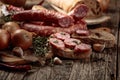 Dry-cured sausage with bread and spices on a old wooden table Royalty Free Stock Photo