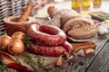 Dry-cured sausage with bread and spices on a old wooden table Royalty Free Stock Photo