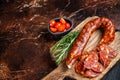 Dry cured Spanish Chorizo sausage, slices of meat with herbs and spices. Dark background. Top view. Copy space Royalty Free Stock Photo