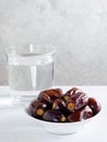 Dry dates and a glass of water on white background. Ramadan, Iftar food concept.