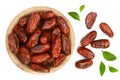 Dry dates with green leaves in wooden bowl isolated on white background. Top view. Flat lay pattern Royalty Free Stock Photo