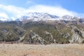 Dry and desolated landscape of rocky hills and snow-capped mountains in the background, Manang Nepal