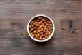 Dry dog food in bowl on wooden background top view Royalty Free Stock Photo