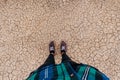 Dry land is covered with small cracks as a concept of drought and global warming. top view on legs in sneakers Royalty Free Stock Photo