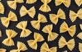 Farfalle pasta pattern on black background, top view, flat lay texture Royalty Free Stock Photo