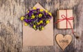 Dry field flowers in a paper envelope. Romantic letter. A wooden heart. Royalty Free Stock Photo