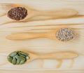 Dry flax, sesame and pumpkin seeds in wooden spoon