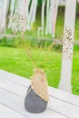 Dry flowers in clay vase on wooden table outdoors