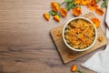 Dry and fresh calendula flowers on wooden table, flat lay. Space for text Royalty Free Stock Photo