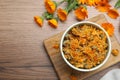 Dry and fresh calendula flowers on wooden table, flat lay. Space for text Royalty Free Stock Photo